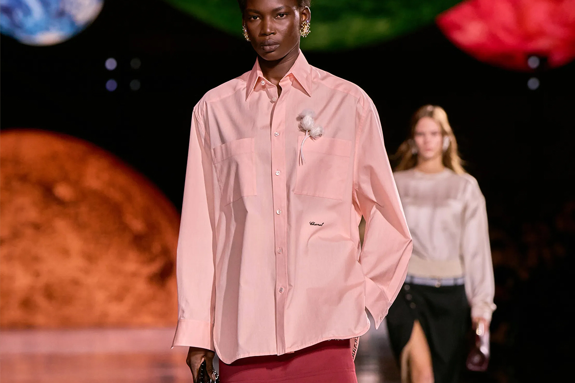 Pembe bluzla yürüyen bir kadın manken